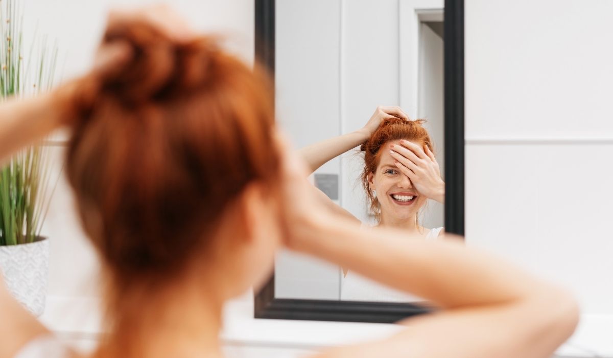 woman looking in mirror during weather changes