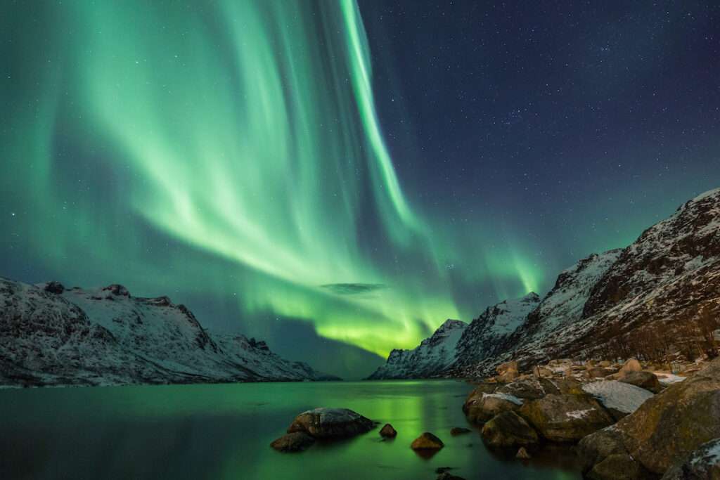 Northern Lights above waters edge during all-inclusive wellness getaway