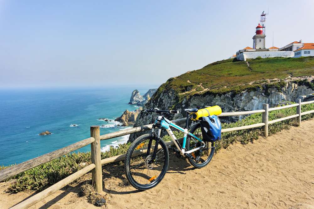 Tourist bike is parked on the westernmost point of the continent Europe. Portugal, Cape Roca.